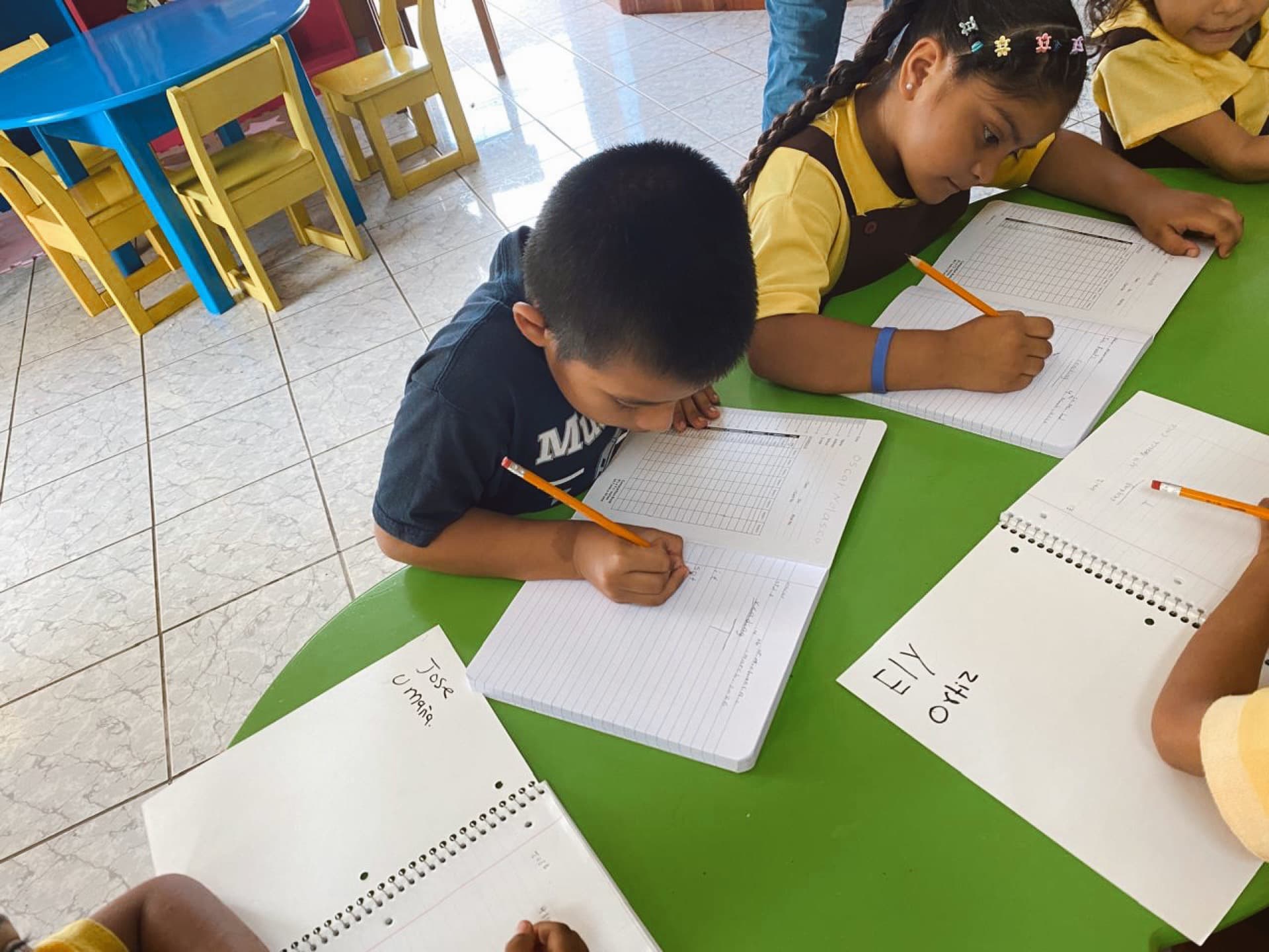 Two kids working through their notebooks together